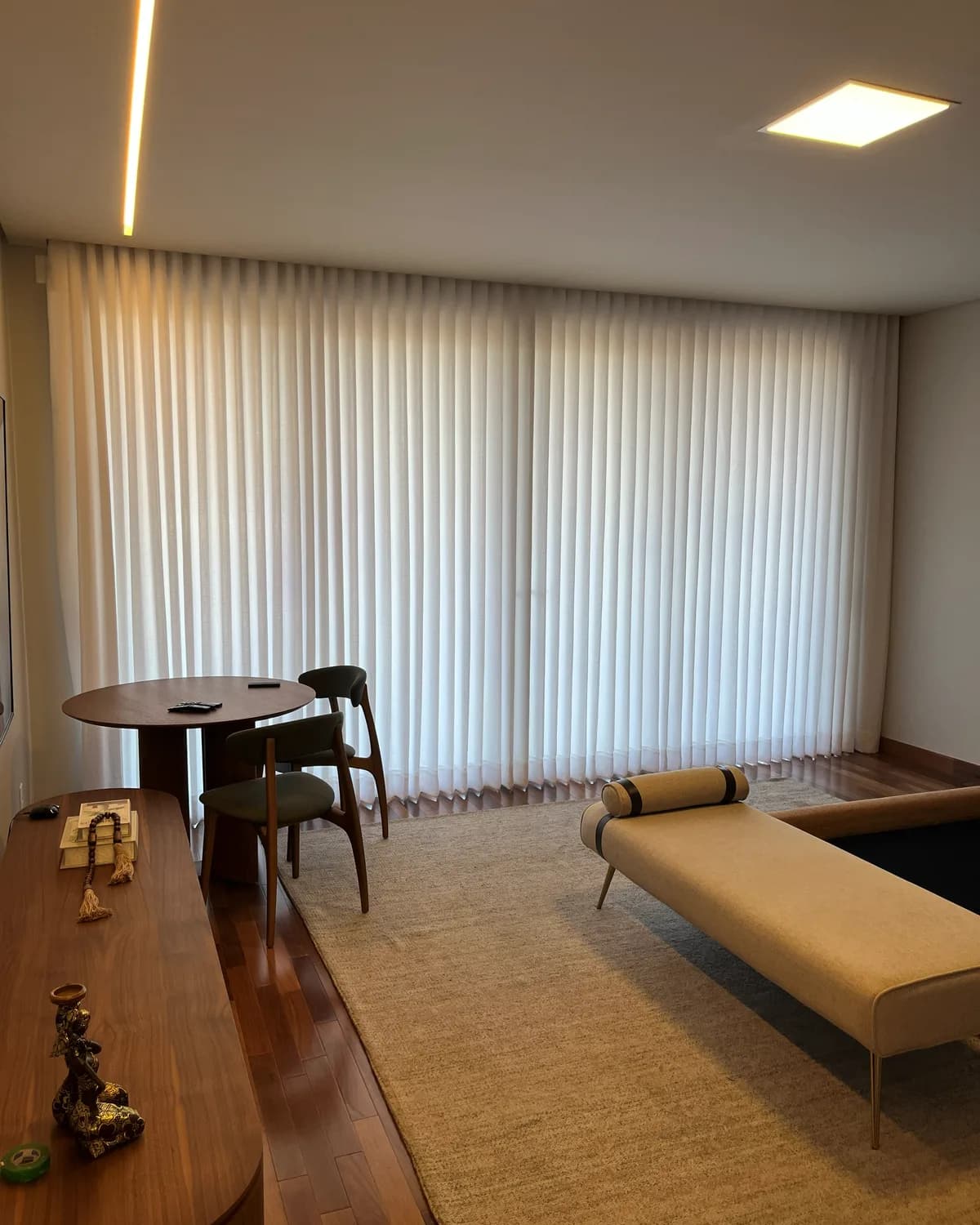 Sala de jantar da Casa no Alphaville, com cortinas voil do piso ao teto cobrindo a parede de janelas