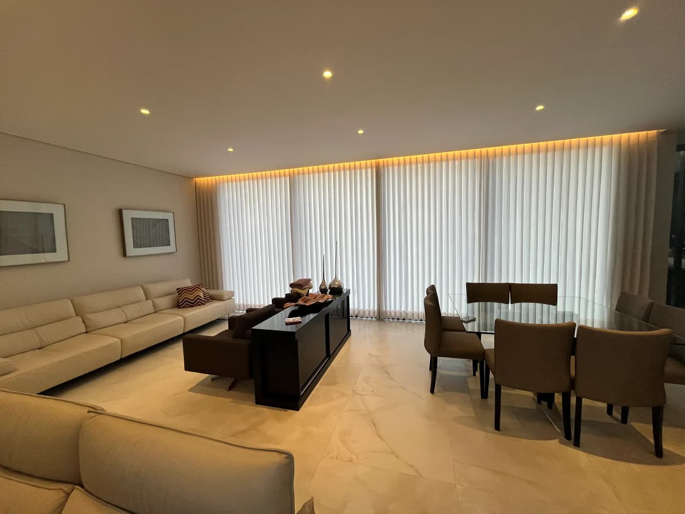 Living da Casa no Alphaville, com cortinas voil ao longo de toda a parede de janelas